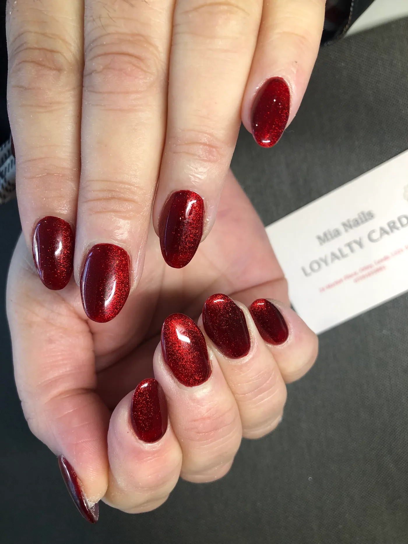 Deep red glitter nails photographed at Mia Nails