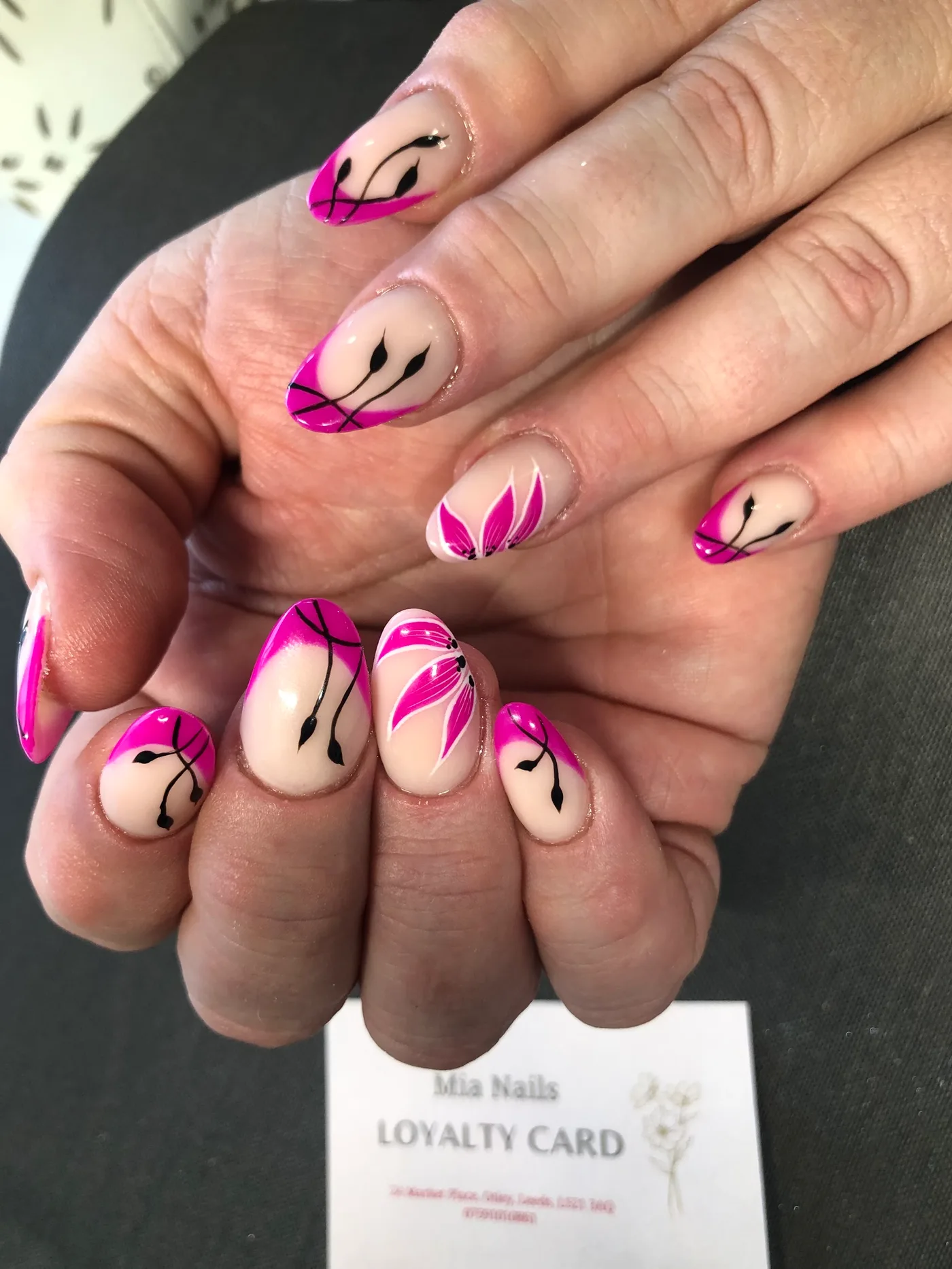 Pink tipped nails with fine black botanical designs