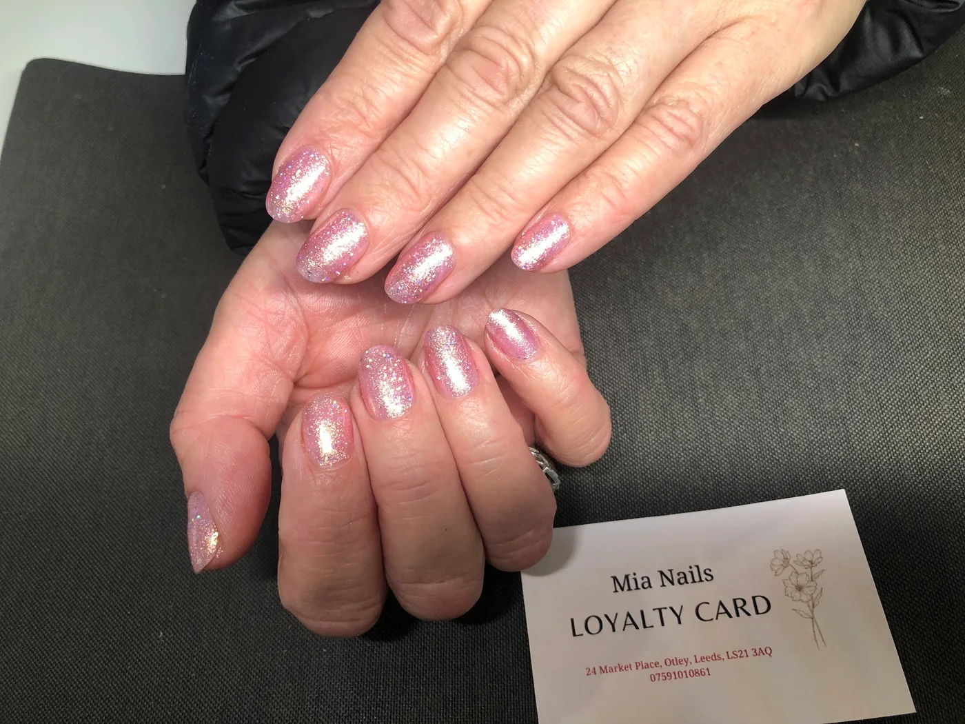 Pink shimmer nails with a Mia Nails loyalty card