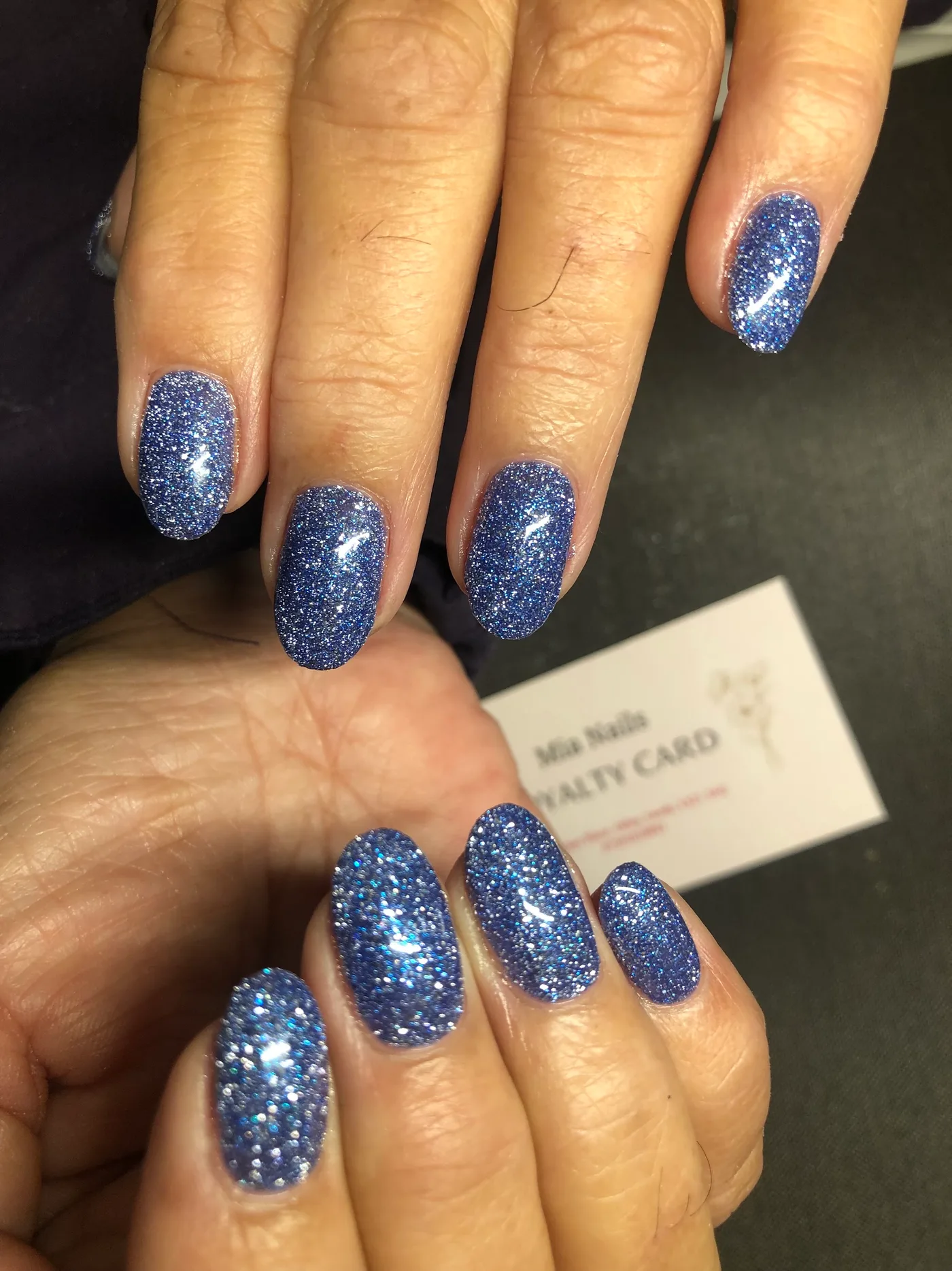 Blue glitter nails with an oval shape